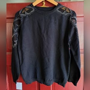 Black sweater with decorative cut off bows on the shoulder and mid-sleeves